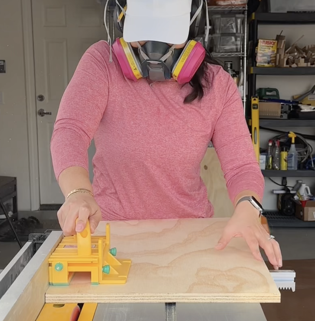 Deedee using a Grr-ripper Pushblock to push a sheet of plywood through a DeWalt table saw